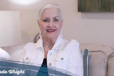 A resident smiling in a cozy living room