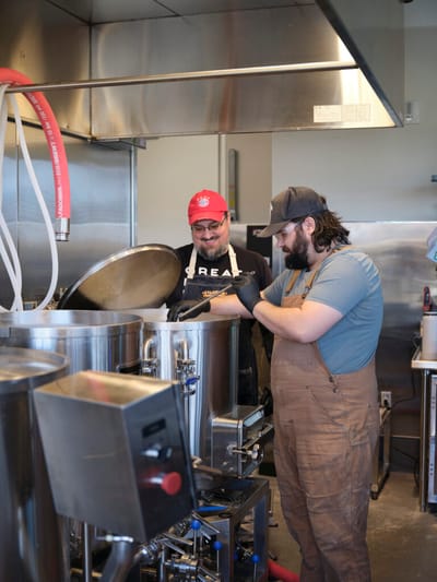 Two staff members cooking in a kitchen