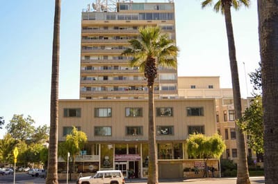 Exterior view of Park Place Apartments building with palm trees