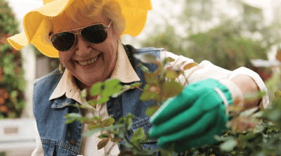 Senior resident gardening outdoors with a bright smile