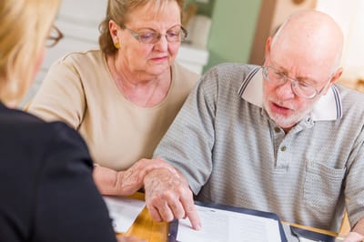 A couple reviewing documents with a staff member