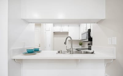 Modern kitchen area with white cabinets