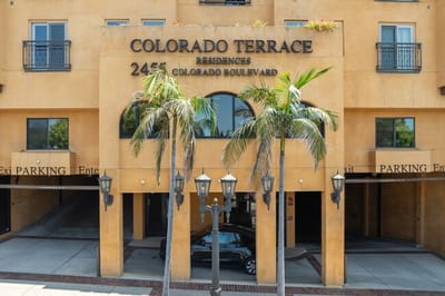 Exterior view of Colorado Terrace apartments with palm trees