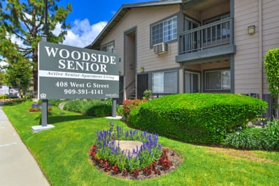 Exterior view of Woodside Senior Apartments with gardens