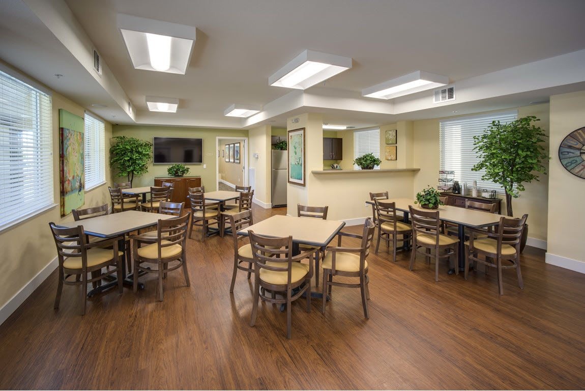 Common area with tables and chairs in a bright room