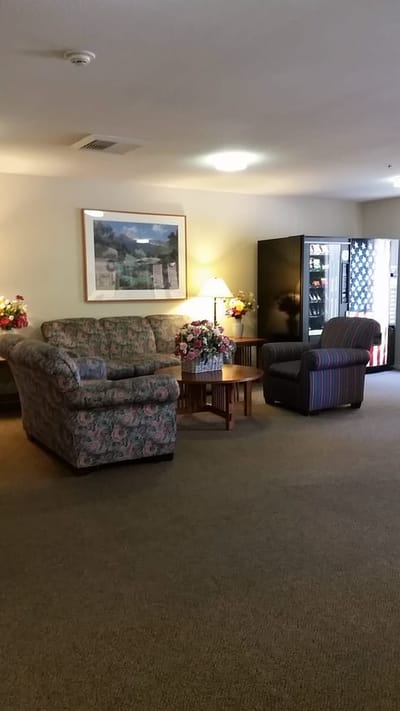 Cozy lounge area with floral seating and a vending machine