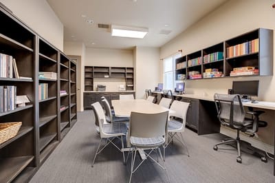 A cozy common area with bookshelves and tables