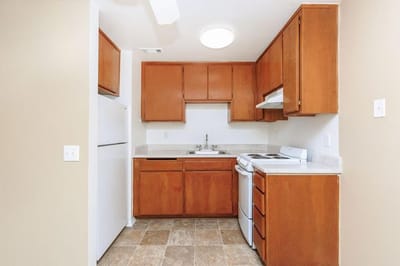 A small kitchen area with wooden cabinets and appliances