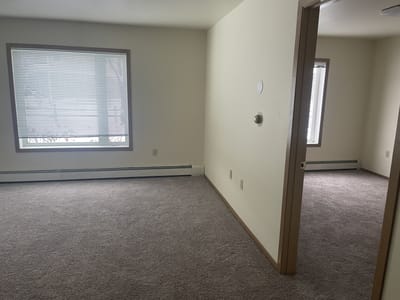 Interior view of a resident room with carpet and windows