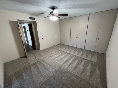 Empty resident room with closet and ceiling fan