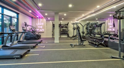 Bright fitness room with gym equipment and motivational lighting