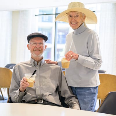 Two residents holding drinks in a common area