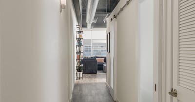 Bright hallway leading to a common area with lounge furniture