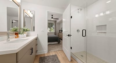 Modern bathroom with shower and bedroom visible