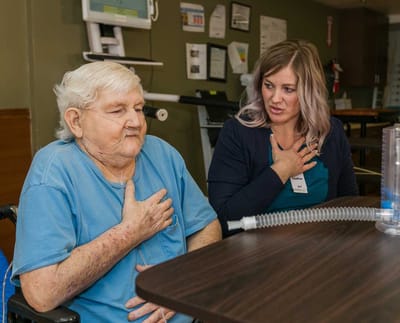 Care staff assisting a resident in a wellness activity