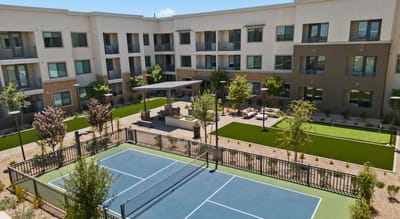 Aerial view of a well-maintained courtyard with tennis court