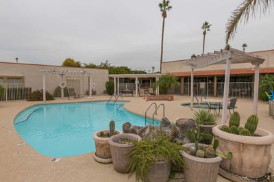 Outdoor pool area with lounge chairs and landscaping