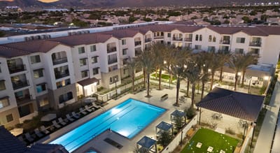 Aerial view of a senior living facility with a pool and landscaped area