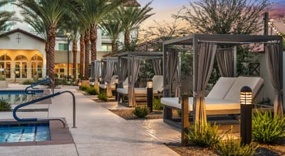 Outdoor lounge area with cabanas and palm trees