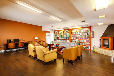 Cozy common area with seating and bookshelf