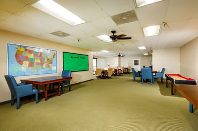 Common area with tables and chairs in a senior living facility