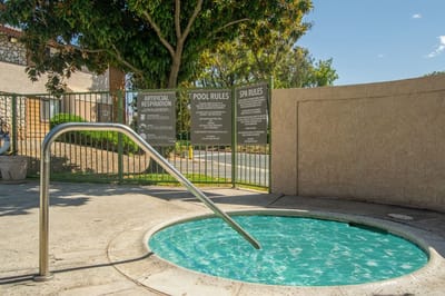 Outdoor spa area with hot tub and pool rules signage