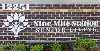 Facility logo on a brick wall with foliage