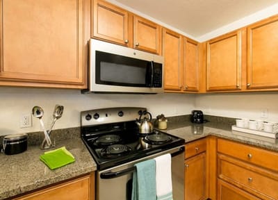 Modern kitchen area with appliances and cabinetry.