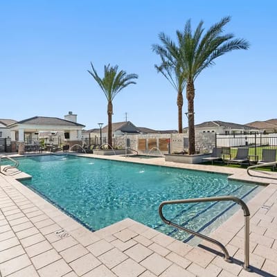 Swimming pool area with palm trees and lounge chairs