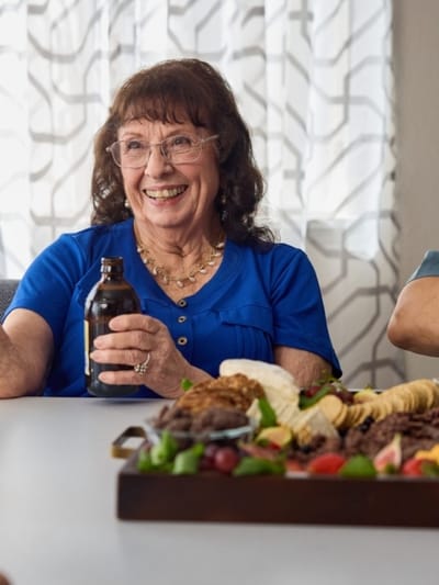 Resident enjoying a meal with a smile.