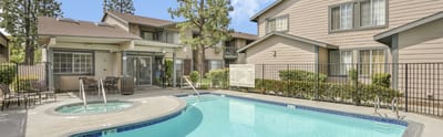Outdoor pool area with seating and greenery