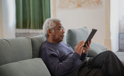 A senior man using a tablet in a cozy living area