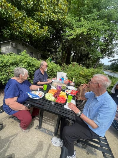 Residents enjoying a picnic outdoors with fresh fruit