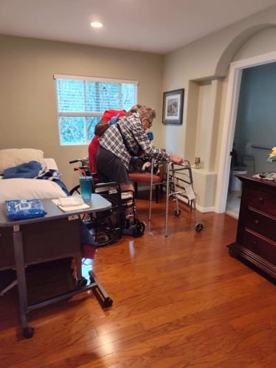 Staff assisting a resident in a private room
