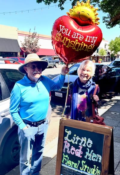 Couple holding a heart-shaped balloon outdoors
