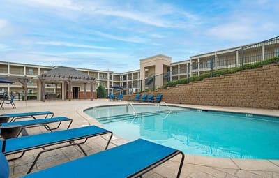 Outdoor pool area with seating and lounge chairs