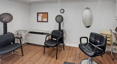 Hair salon area with styling chairs and dryers