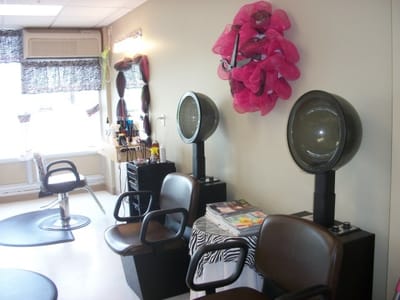 Beauty salon area with hair styling chairs and hairdryers