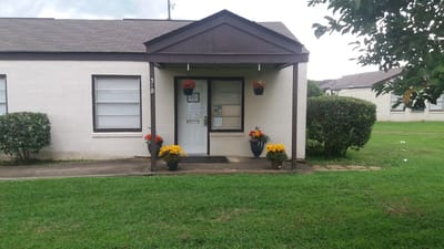 Exterior view of facility entrance with decorative flowers