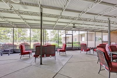 Covered outdoor seating area with red chairs