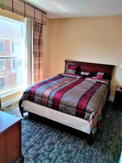 Stylish private bedroom with a large window and patterned bedding