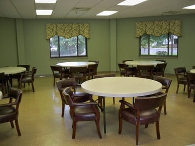 A bright common area with round tables and chairs