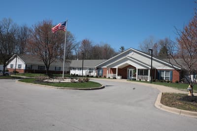 Exterior view of a senior living facility with American flag