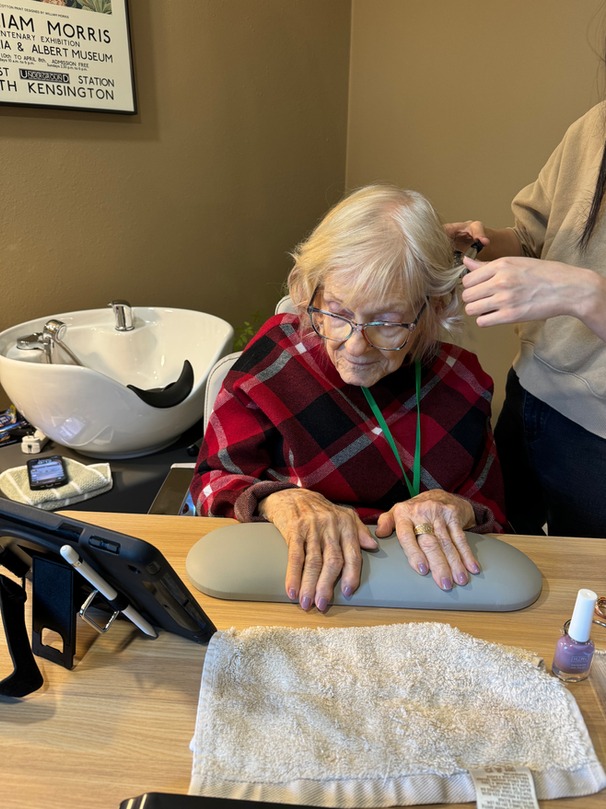 Resident receiving a salon service in a cozy interior.