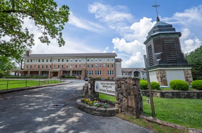 Exterior view of a senior living facility with lush greenery