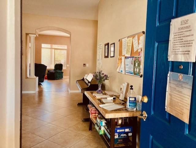 View of a hallway with a blue door and bulletin board