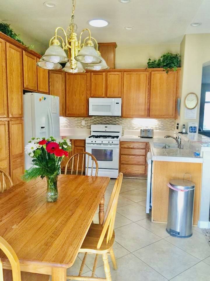 Bright kitchen with wooden cabinets and flowers on the table