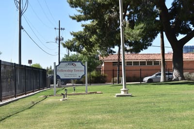 Exterior view of the Fellowship Towers sign with landscaping