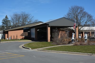 Exterior view of St. Ann's Home with entrance and flag