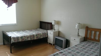 A simple interior room with two beds and lamps